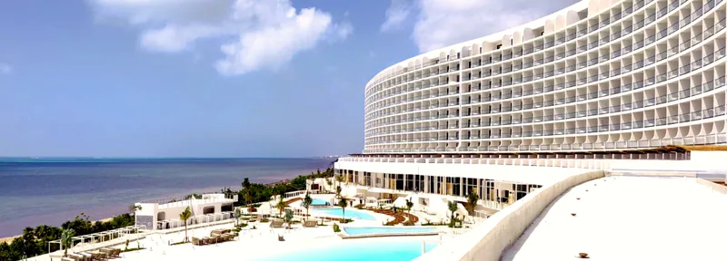 Fachada terminada del Hotel AVA Cancún con albercas y mar de fondo