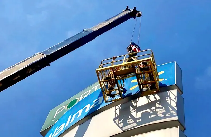 Canastilla de grúa sobre tótem publicitario de Walmart Sinaloa
