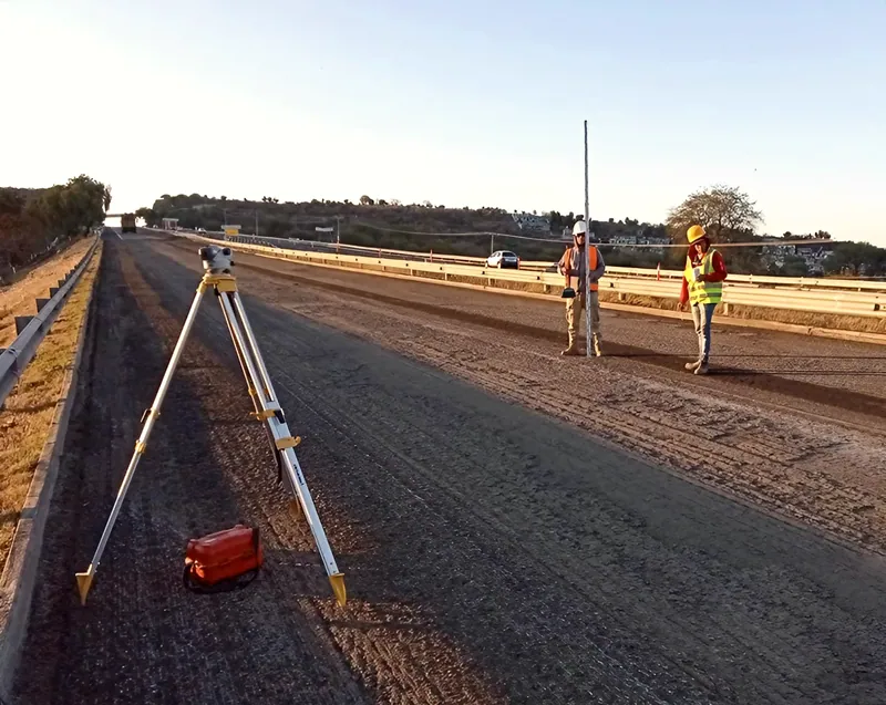 Nivelación con estadal sobre base hidráulica en obra carretera